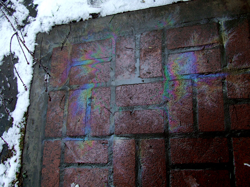 chainsaw oil-leak rainbows on bricks