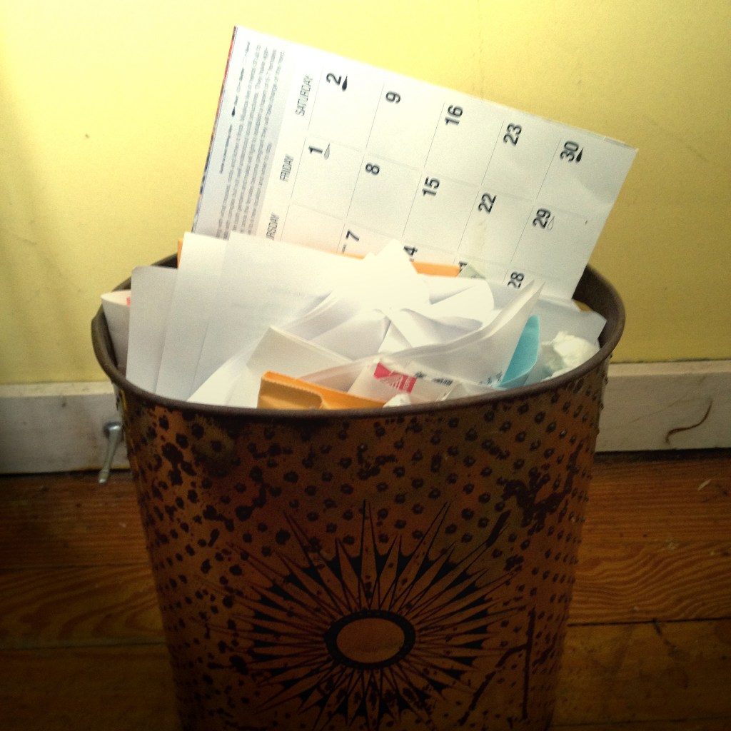 a wall calendar in a metal trash can with a solar design on the side of it